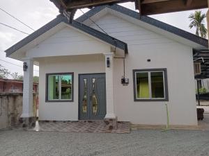 una piccola casa bianca con un tubo verde di K&A Family Homestay a Kuala Terengganu