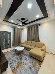 un soggiorno con un divano e un tavolo di K&A Family Homestay a Kuala Terengganu