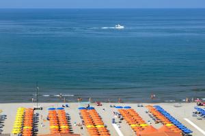 una vista sul tetto di una spiaggia con sedie e ombrelloni di Grand Hotel Royal a Viareggio