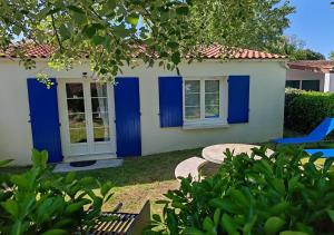 a house with blue doors and a yard at Les Cariatides in La Cotinière