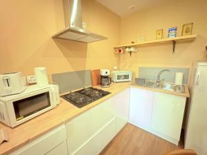 a kitchen with a microwave and a stove top oven at Studio MARGAUX in Patornay +1 photo