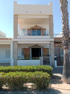 ein Gebäude mit einer Palme davor in der Unterkunft Els Vents primera línea playa Puçol in Playa de Mar