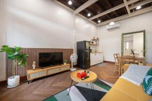 un soggiorno con televisione e tavolo di Moondance House Chinatown a Bangkok