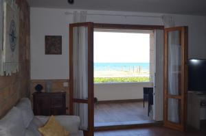 ein Wohnzimmer mit Blick auf den Strand in der Unterkunft Els Vents primera línea playa Puçol in Playa de Mar