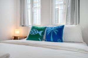 un letto con cuscini blu e verdi di Moondance House Chinatown a Bangkok