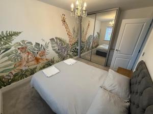a bedroom with a bed with a mural of giraffes at Cheshire home by Chelsea in Macclesfield