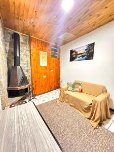 un salon avec un lit et une cheminée dans l'établissement My Yellow House aconchego, à Campos do Jordão