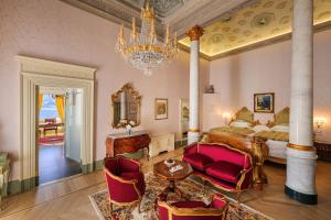 a bedroom with a bed and a chandelier at Grand Hotel Villa Serbelloni - The only Relais & Châteaux on Lake Como in Bellagio