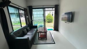 una sala de estar con un sofá y una mesa en Cha-emHouse1 Baantai, en Thong Sala