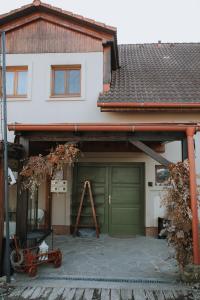 a garage with a green garage door in front of a house at Penzión Čarovný dvor in Gregorovce