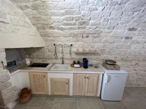 a kitchen with a sink and a white brick wall at L'arco dei sogni in Ceglie Messapica