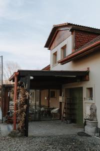 a house with awning and a table and chairs at Penzión Čarovný dvor in Gregorovce