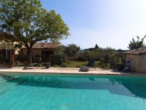 a swimming pool with a chair next to a house at chambre d hotes la dragonne in Maubec