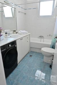 a bathroom with a sink and a toilet and a tub at Magdalena Cozy Apartment in Sparti