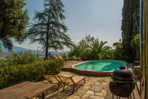 a swimming pool in a yard with a table and chairs at Villa Pedone in Lucca