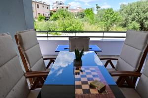 a table and chairs on a balcony with a chessboard at Magdalena Cozy Apartment in Sparta