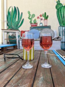 two glasses of wine sitting on a wooden table at Bohemian Holiday House in Siófok