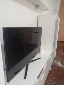a flat screen tv sitting on top of a white cabinet at Centro 3 - Pescadería in Jaén