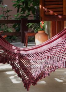 a hammock in a room with a plant at Na Villa dos Algodões in Marau