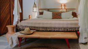 a bedroom with a bed and a table with a hat on it at Na Villa dos Algodões in Marau