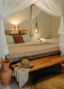 a bedroom with a large bed with a wooden bench at Na Villa dos Algodões in Marau