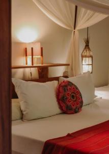 a bedroom with a bed with white pillows at Na Villa dos Algodões in Marau