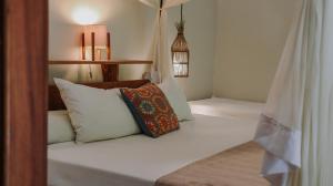a bedroom with a bed with pillows on it at Na Villa dos Algodões in Marau
