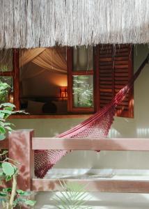 a hammock hanging from a thatch roof at Na Villa dos Algodões in Marau