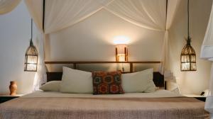 a bedroom with a bed with white pillows at Na Villa dos Algodões in Marau