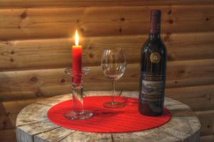 a candle and a bottle of wine and a glass at Cottage On Wild River In Lapland/Sweden in Karlsten