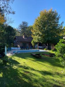 a house with a yard with benches in front of it at Alojamiento casaquinta en Ezeiza in La Unión