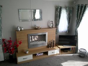 a living room with a tv and a fireplace at Mayville Parkstone 6 Berth Central heated in Ingoldmells