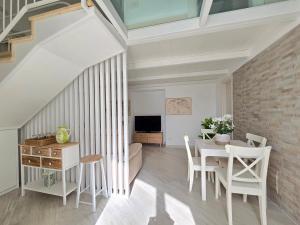 a living room with a table and chairs at Grazy Home - Bright new Apt with Terrace and Seasonal Pool in Vico Equense