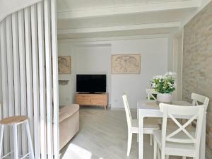 a living room with a table and a television at Grazy Home - Bright new Apt with Terrace and Jacuzzi in Vico Equense
