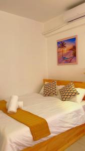 two twin beds in a bedroom with a painting on the wall at Bella Stay Inn in Male City +11 photos