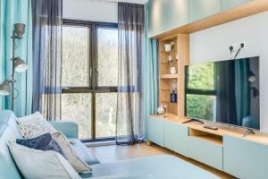 a living room with a blue couch and a large window at City Line Apartment 2 in Newtownabbey