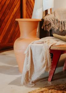 a vase sitting next to a table with a blanket at Na Villa dos Algodões in Marau