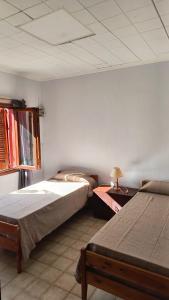 een slaapkamer met twee bedden en een tafel met een lamp bij Casa Quinta Pichi Ruca in Coronel Suárez