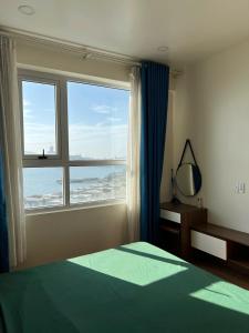 Un dormitorio con una cama y una ventana grande. en Le Jardin Homestay - 2BR Apt with stunning sea view, en Ha Long