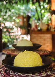 two black plates with a yellow cake on a table at Na Villa dos Algodões in Marau