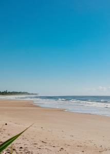 an empty beach with the ocean in the background at Na Villa dos Algodões in Marau