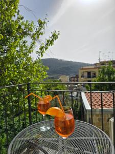 two wine glasses on a table on a balcony at Grazy Home - Bright new Apt with Terrace and Jacuzzi in Vico Equense