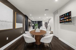 a dining room with a wooden table and white chairs at Stylish 3BR Designer Home in Harlem! in New York