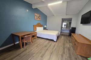 una camera da letto con un letto, una scrivania e una televisione di Luxury Inn & Suites a Nacogdoches