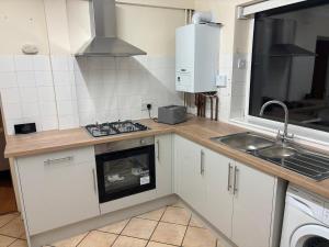 a kitchen with a sink and a stove top oven at 3-bed house with parking in CB1 in CBG +6 photos
