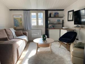 ein Wohnzimmer mit Sofa und Tisch in der Unterkunft Charmant appartement au coeur de la ville in La Rochelle