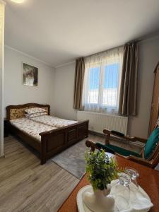 a bedroom with a bed and a table and a chair at Hostel „La Galan” in Rădăuţi