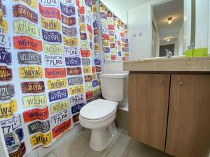 维纳德马Comodo Depto con hermosa vista的一间带马桶的浴室和一面摆满啤酒罐的墙