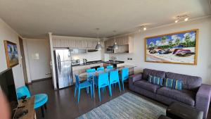 维纳德马Comodo Depto con hermosa vista的客厅里有一张沙发、一张桌子和几把椅子。