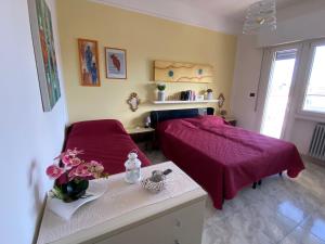 a bedroom with a bed and a table with flowers on it at Ravenna d Amare 2 in Marina di Ravenna
